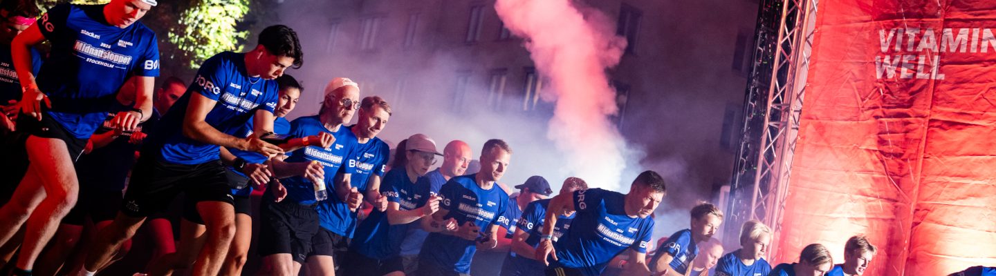 Startskottet går och löpare springer igenom startportalen under Midnattsloppet Stockholm 2026