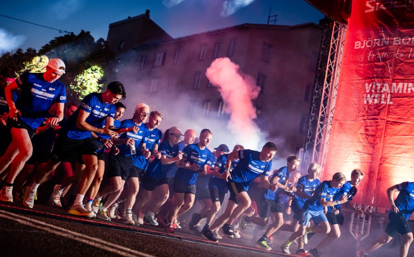 Startskottet går och löpare springer igenom startportalen under Midnattsloppet Stockholm 2026