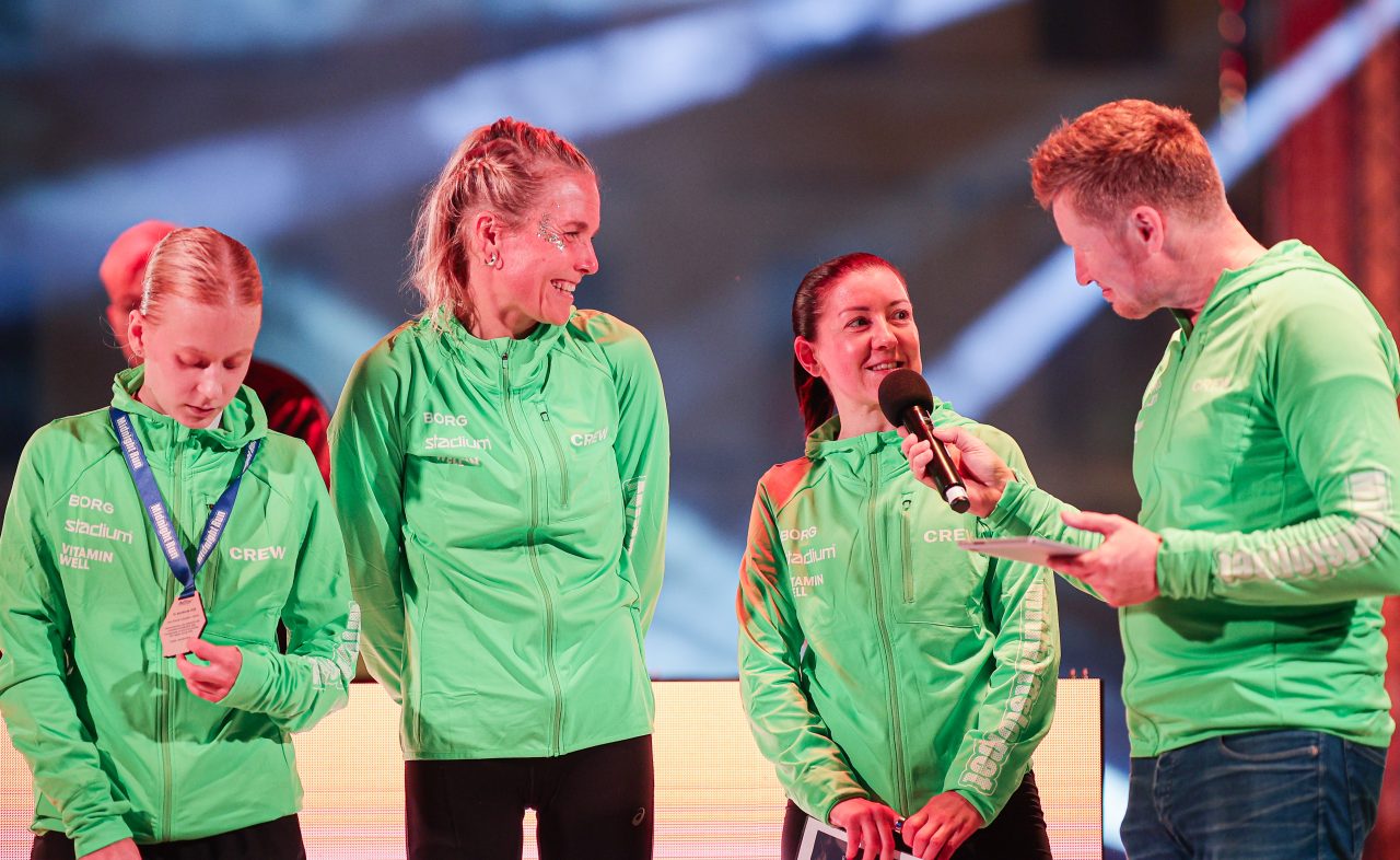 Tredjepristagaren i damklassen blir intervjuad av speaker på scenen under Midnight Run Helsinki 2026