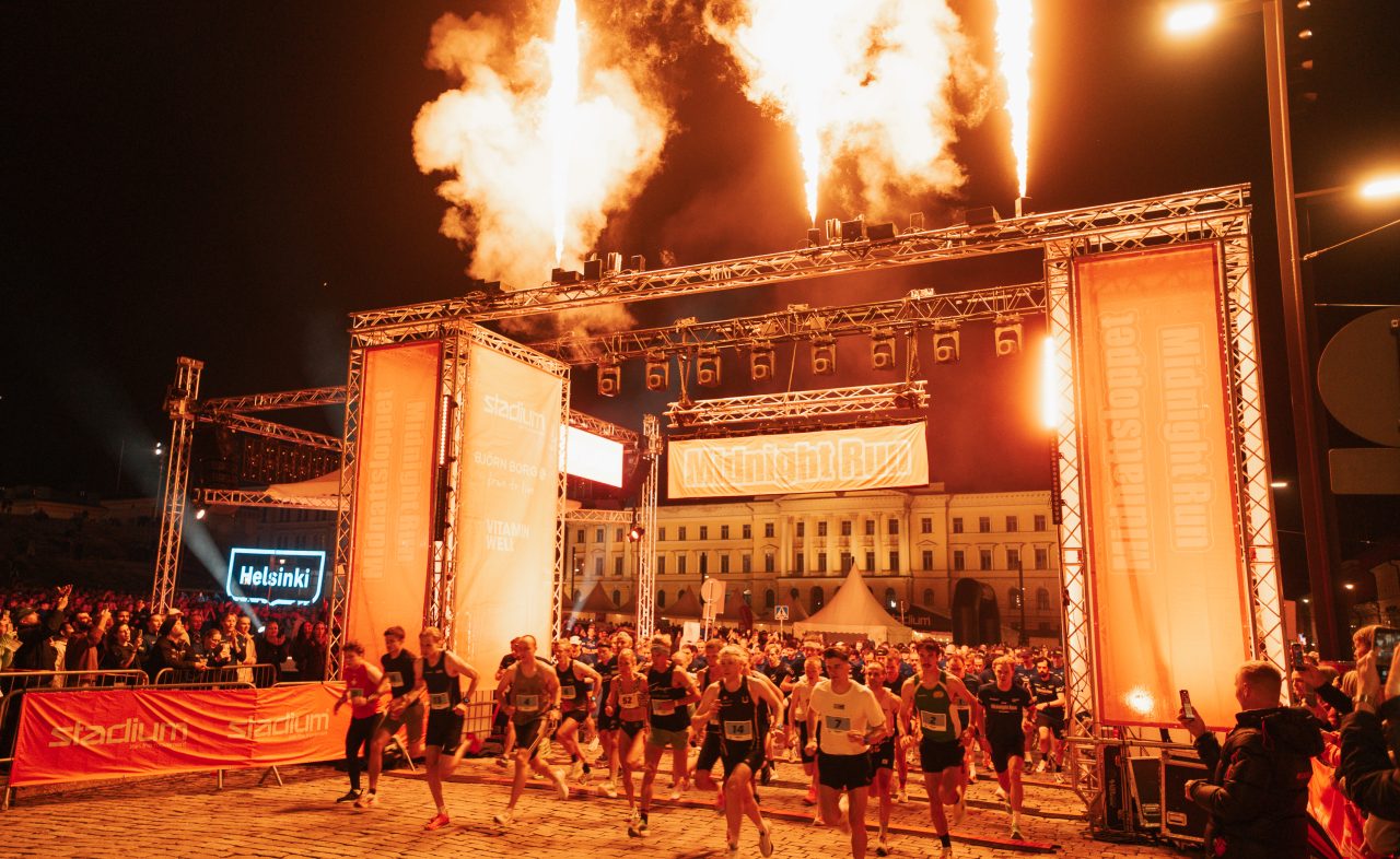 Eld i startportalen när första startskottet går och eliten springer iväg från starten av Midnight Run Helsinki 2026