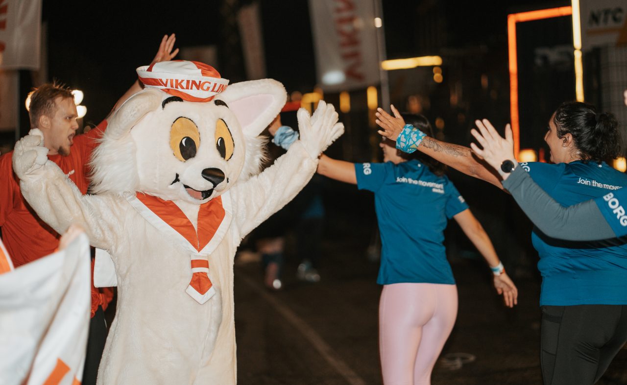 Ville Viking och Viking Line hejar på löparna med high five under Midnight Run Helsinki 2026