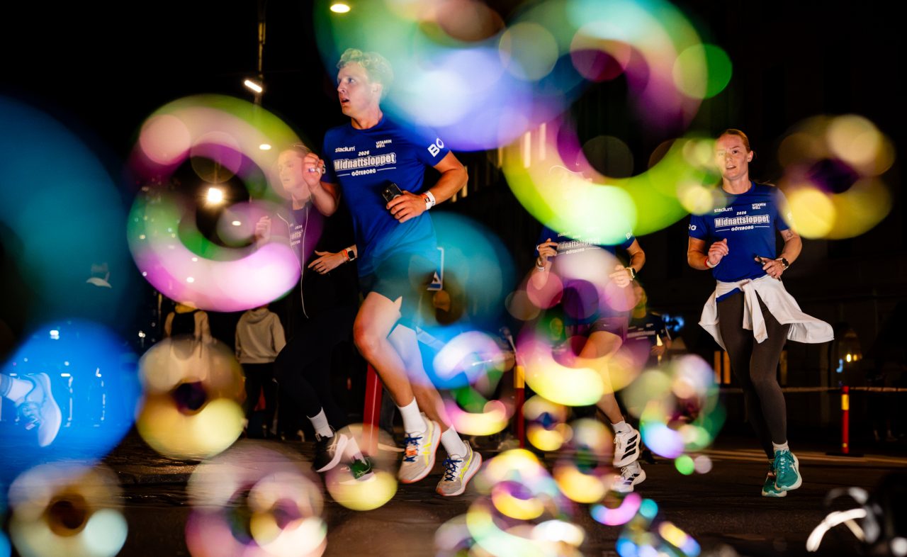 Löpare som springer igenom blåsbubblor under Midnattsloppet Göteborg 2026
