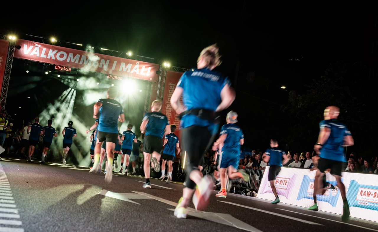Välkommen i mål, löpare springer in i mål under Midnattsloppet Stockholm 2026
