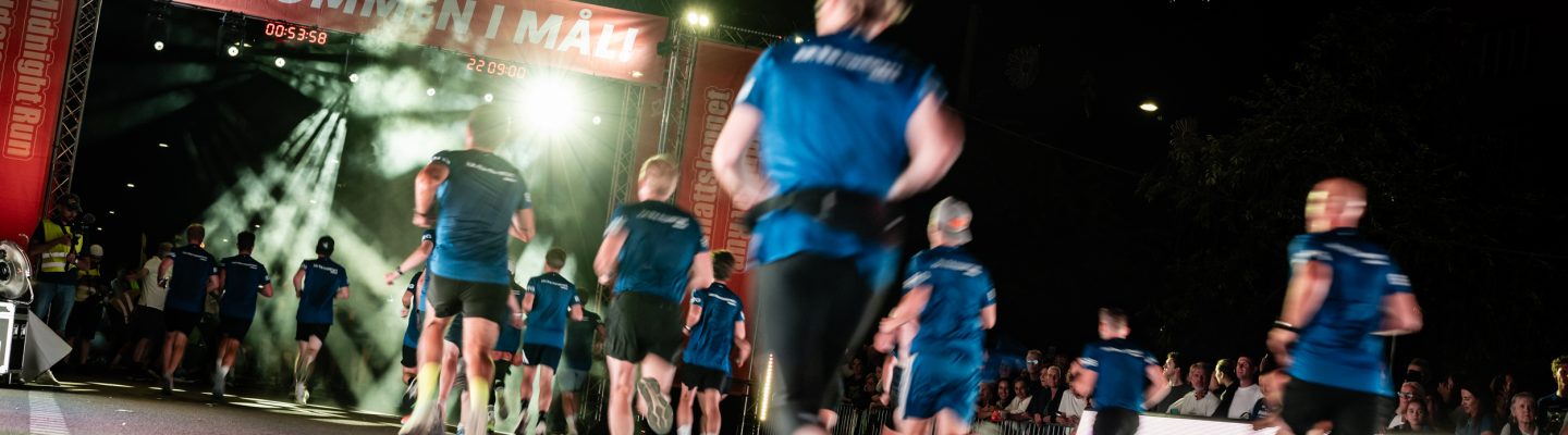 Välkommen i mål, löpare springer in i mål under Midnattsloppet Stockholm 2026
