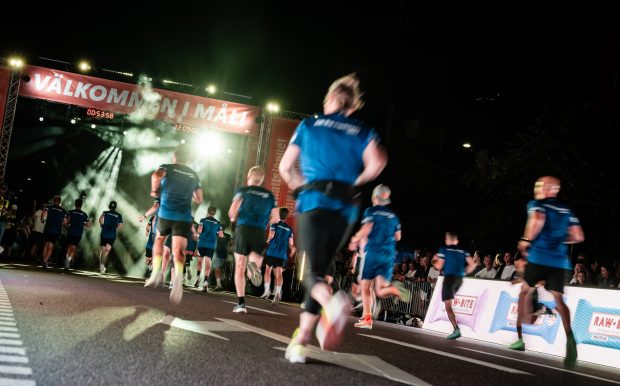 Välkommen i mål, löpare springer in i mål under Midnattsloppet Stockholm 2026
