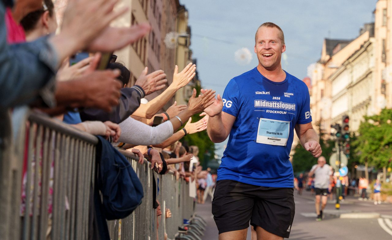 Deltagare som gör high five med publiken mot mål under Glada Midnattsloppet 2026