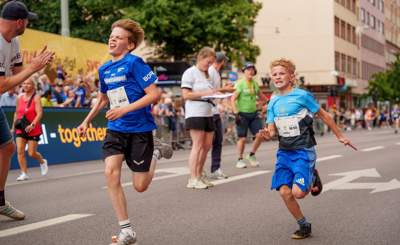 Två killar som spurtar in i en duell mot målet under Lilla Midnattsloppet 2026
